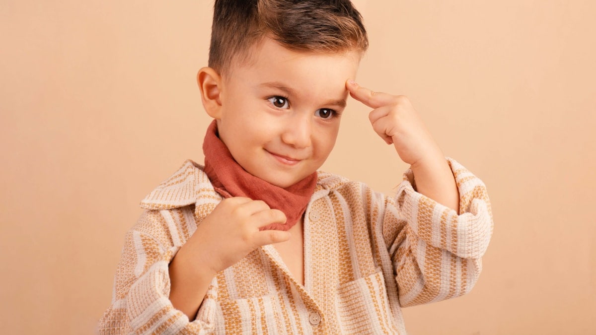 Young boy with finger on temple, his temple
